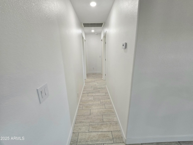 hallway with recessed lighting, baseboards, visible vents, and wood finish floors