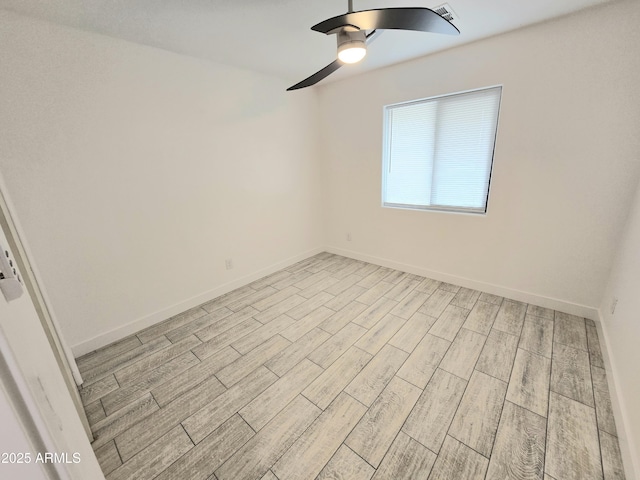 unfurnished room with ceiling fan, light wood finished floors, and baseboards