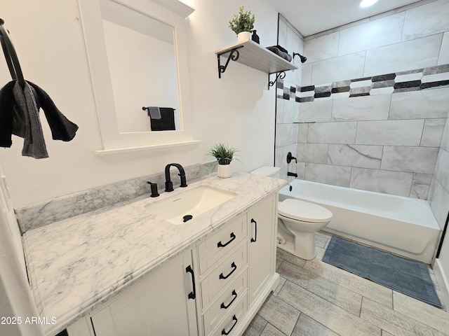 bathroom featuring bathtub / shower combination, vanity, and toilet