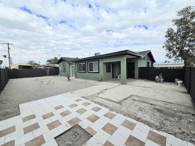 view of front of property with a patio area, a fenced backyard, and stucco siding