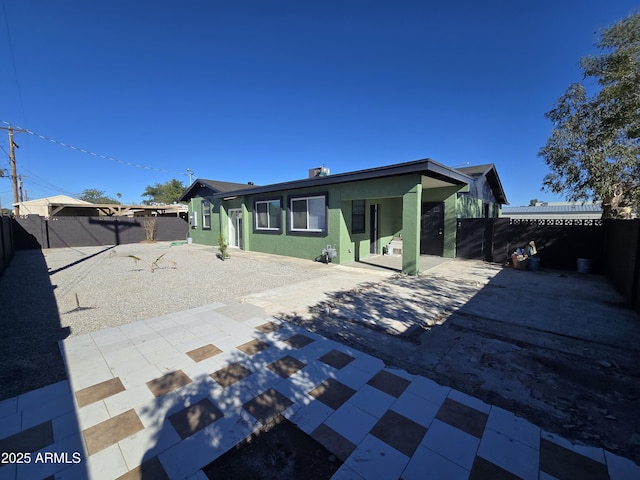 back of property with a fenced backyard, a patio, and stucco siding