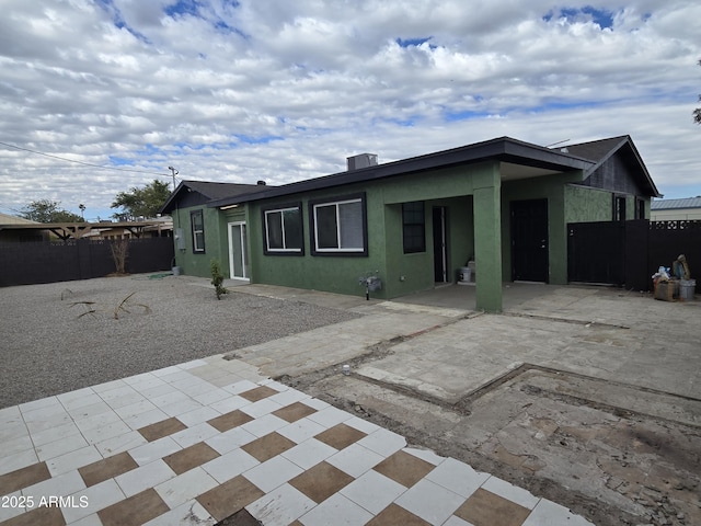 back of property featuring cooling unit, a patio area, fence, and stucco siding