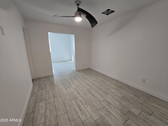 unfurnished room with a ceiling fan, light wood-type flooring, and baseboards