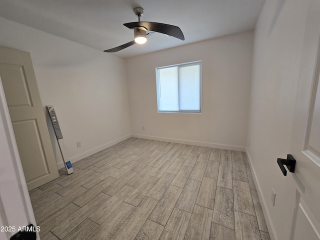 empty room with light wood-style floors, ceiling fan, and baseboards