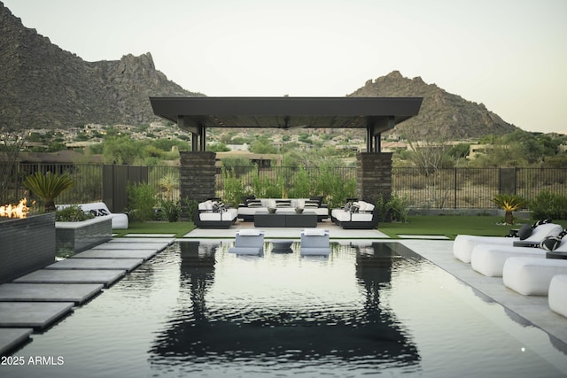 view of property's community with a pool, an outdoor hangout area, a mountain view, and a patio area