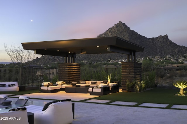 patio terrace at dusk featuring an outdoor hangout area and a mountain view