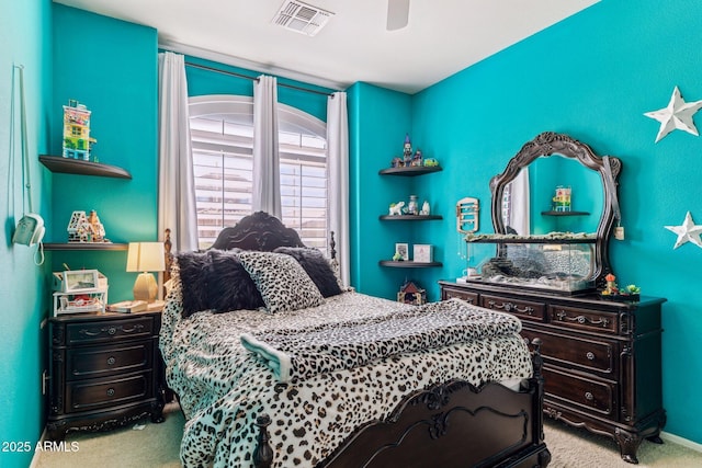 carpeted bedroom with a ceiling fan and visible vents