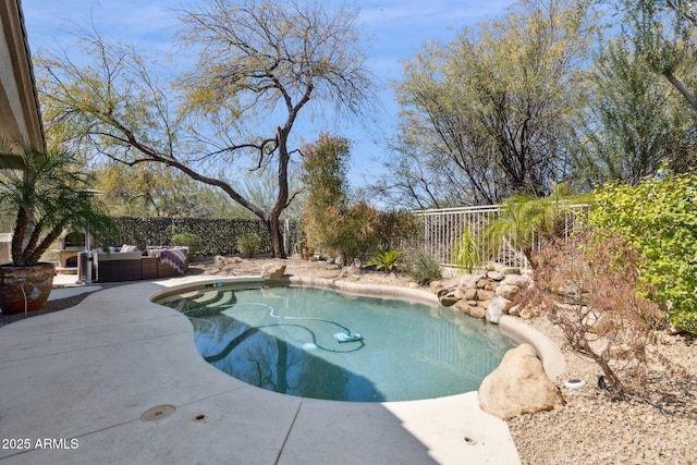 view of pool with an outdoor living space, a patio area, and a fenced backyard