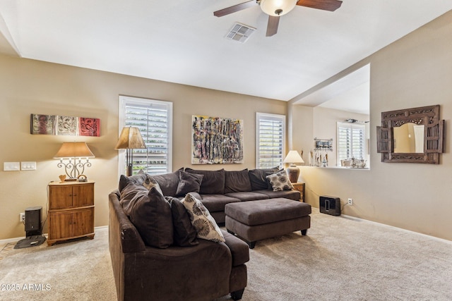 living area with a ceiling fan, light colored carpet, visible vents, and baseboards