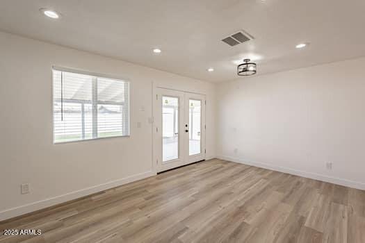 foyer with plenty of natural light, light wood finished floors, baseboards, recessed lighting, and french doors