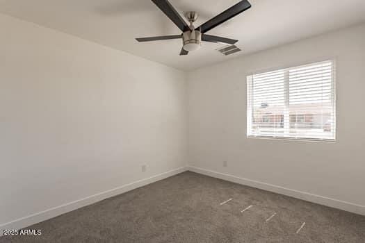 spare room featuring baseboards, carpet floors, and ceiling fan