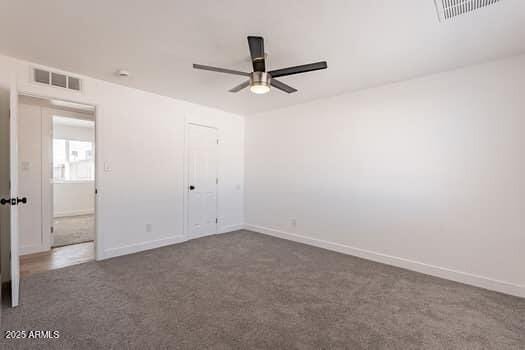 unfurnished bedroom with carpet floors, baseboards, a ceiling fan, and a closet