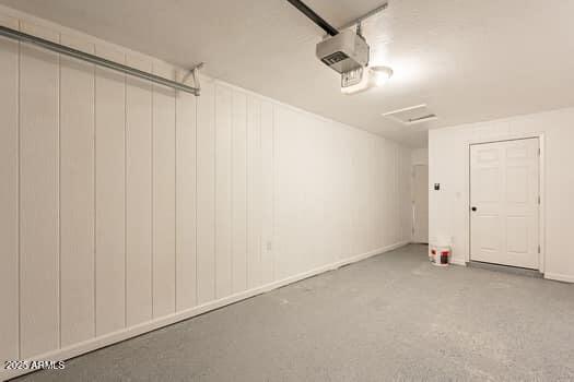 garage featuring a garage door opener and baseboards
