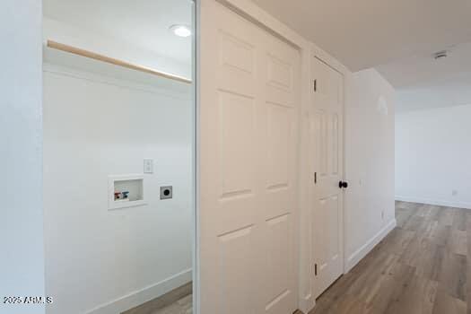 laundry area featuring electric dryer hookup, washer hookup, baseboards, and wood finished floors