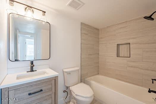 bathroom with toilet, vanity, and bathing tub / shower combination