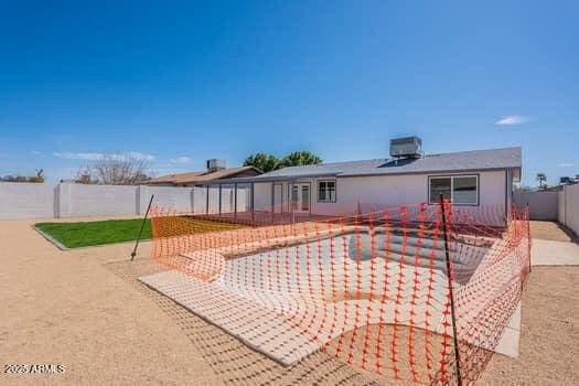 back of property with a fenced backyard, a patio, and central air condition unit