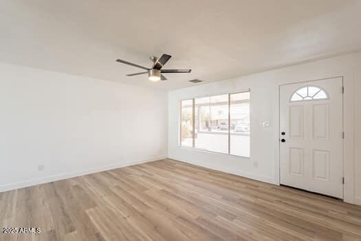 entryway with light wood finished floors, a ceiling fan, and baseboards