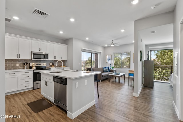 475 N 9th St Unit 206, Phoenix, AZ 85006 - kitchen with stainless steel appliances, open floor plan, decorative backsplash, light wood-style flooring, and light countertops