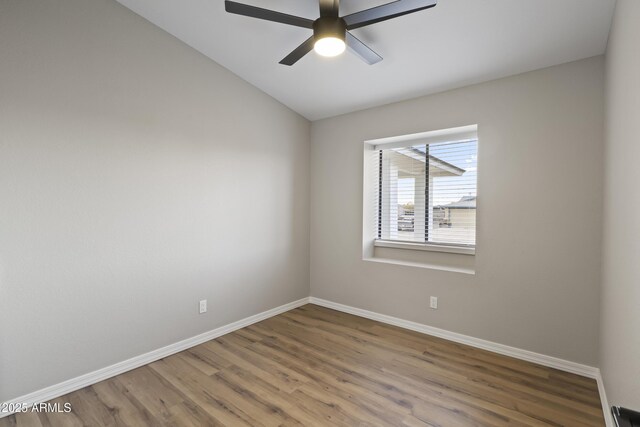 unfurnished room featuring ceiling fan, hardwood / wood-style floors, and vaulted ceiling