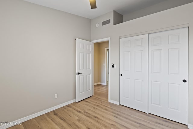 unfurnished bedroom with ceiling fan, a closet, and light wood-type flooring