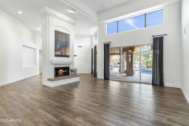 unfurnished living room with a towering ceiling and dark hardwood / wood-style floors