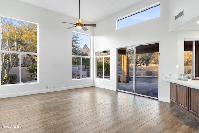 unfurnished sunroom featuring ceiling fan