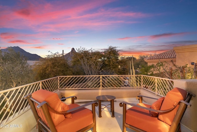 balcony at dusk featuring a mountain view