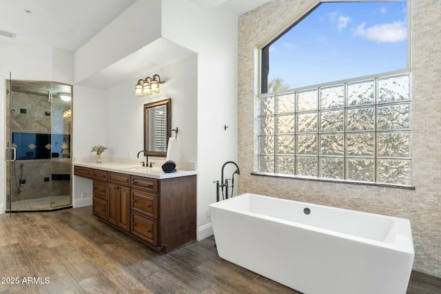 bathroom with vanity, hardwood / wood-style floors, and separate shower and tub