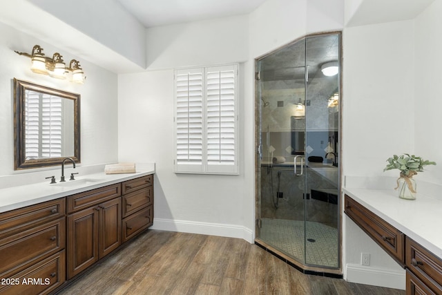 bathroom featuring hardwood / wood-style flooring, vanity, and a shower with shower door