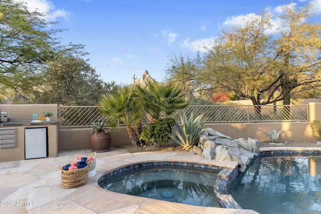 view of swimming pool with an outdoor kitchen, a patio, and an in ground hot tub