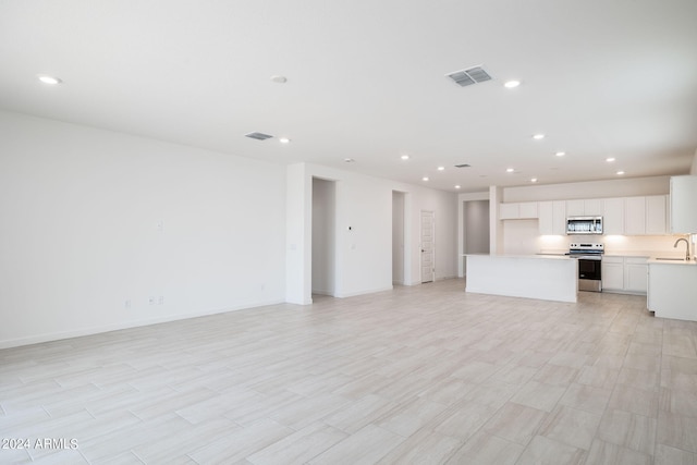 unfurnished living room with sink