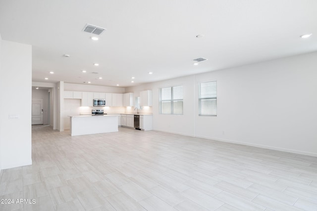 unfurnished living room featuring sink