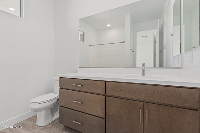 bathroom with vanity, a shower, hardwood / wood-style flooring, and toilet