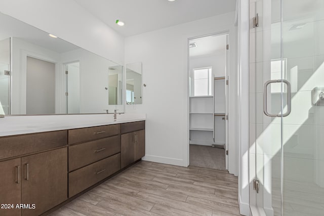 bathroom with vanity, an enclosed shower, and wood-type flooring