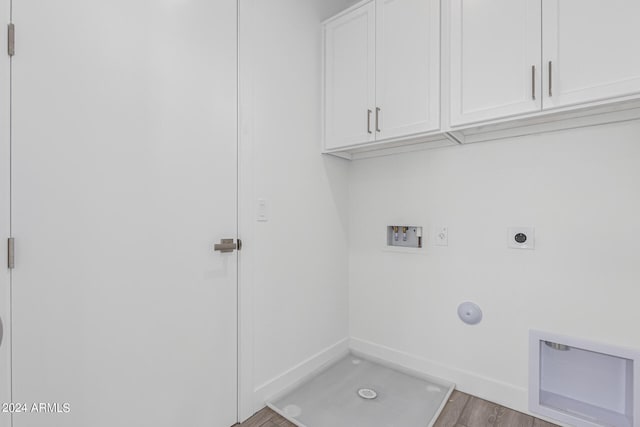 washroom with light hardwood / wood-style flooring, hookup for a washing machine, hookup for an electric dryer, gas dryer hookup, and cabinets