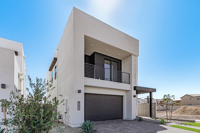 contemporary house featuring a garage and a balcony