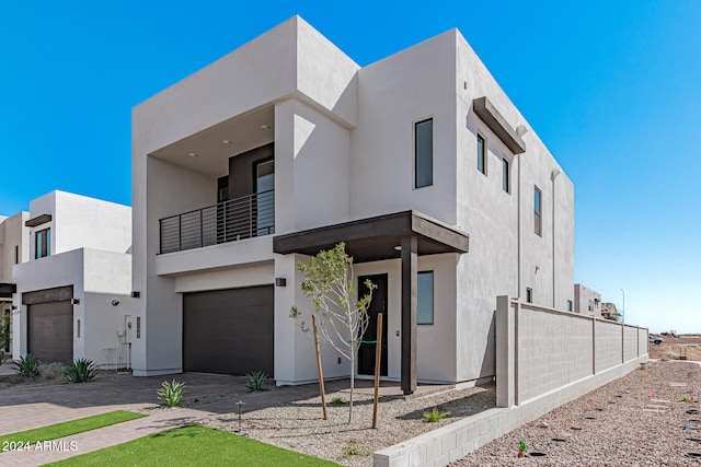 view of front of house featuring a garage and a balcony