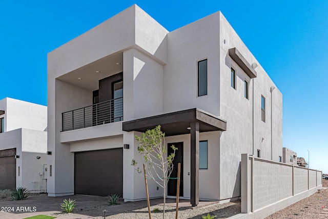 view of front of home with a garage and a balcony