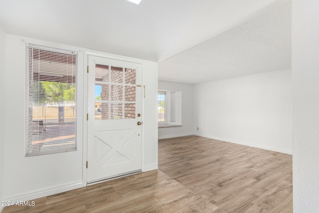 doorway featuring a textured ceiling and light hardwood / wood-style flooring