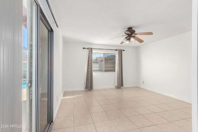 spare room featuring ceiling fan and light tile patterned floors