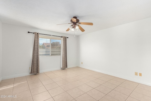 tiled empty room with a textured ceiling and ceiling fan