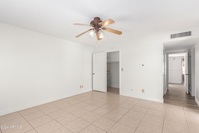 tiled spare room featuring ceiling fan and a textured ceiling