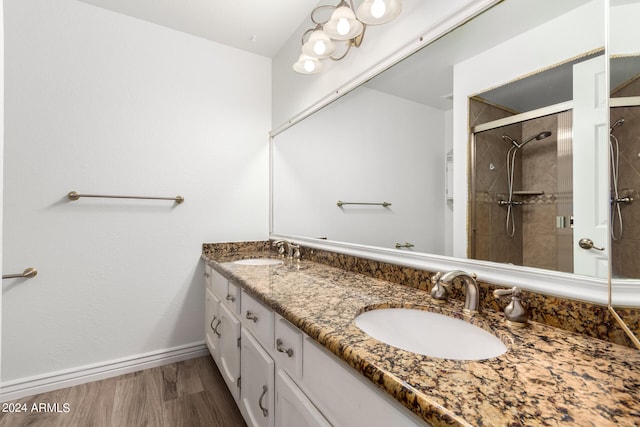 bathroom with a tile shower, hardwood / wood-style floors, and vanity