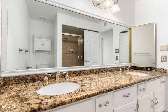 bathroom featuring vanity, toilet, and a shower with shower door