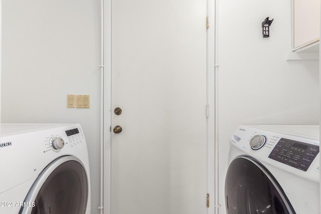 laundry room featuring cabinets and washing machine and clothes dryer