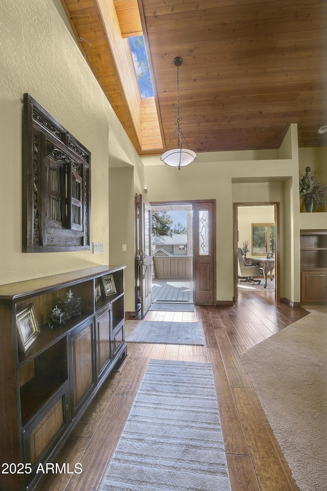foyer featuring wood ceiling, wood-type flooring, a skylight, and baseboards