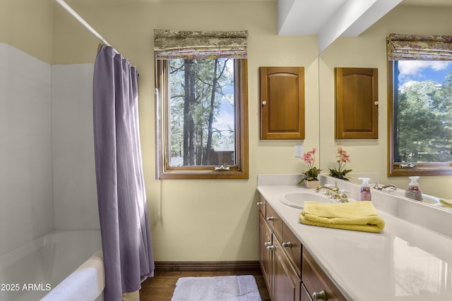 full bathroom with vanity, baseboards, wood finished floors, and shower / tub combo with curtain