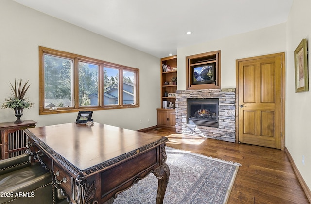 office area featuring wood finished floors, a fireplace, baseboards, built in features, and recessed lighting