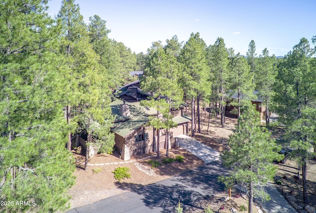 aerial view of property and surrounding area with a heavily wooded area