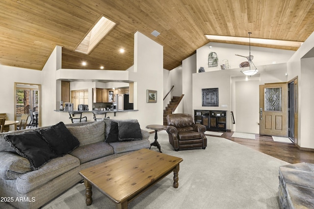 living area with wood ceiling, high vaulted ceiling, a skylight, stairway, and recessed lighting